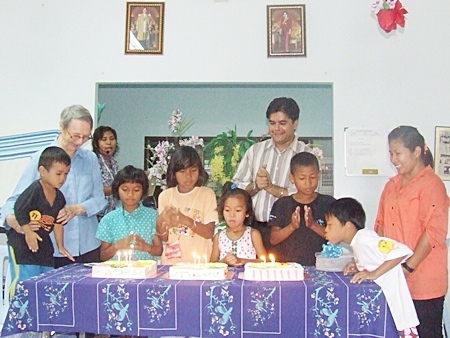 Sister Joan and Tony cheer as the birthday children blow out the candles on the birthday cakes.